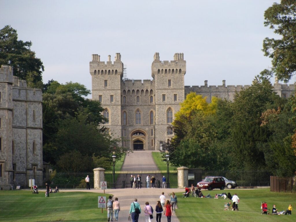 Windsor Castle 5 A twin-turreted stone gateway at the end of a broad avenue, with people sitting on the grass on either side