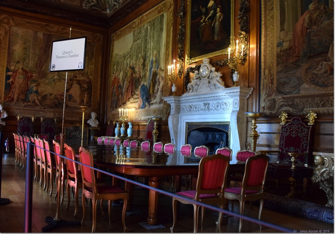 A state room hung with tapestries between carved and gilded festoons, with a long polished table, crimson chairs and a white marble chimneypiece A state room hung with tapestries between carved and gilded festoons, with a long polished table, crimson chairs and a white marble chimneypiece