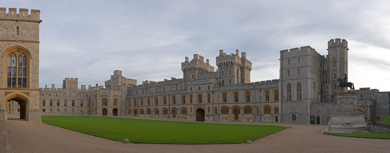 Panoramic view of the grass quadrangle of Windsor Castle's Upper Ward, enclosed on three sides by battlemented stone ranges, with a gate tower at one end and an equestrian statue at the other Panoramic view of the grass quadrangle of Windsor Castle's Upper Ward, enclosed on three sides by battlemented stone ranges, with a gate tower at one end and an equestrian statue at the other