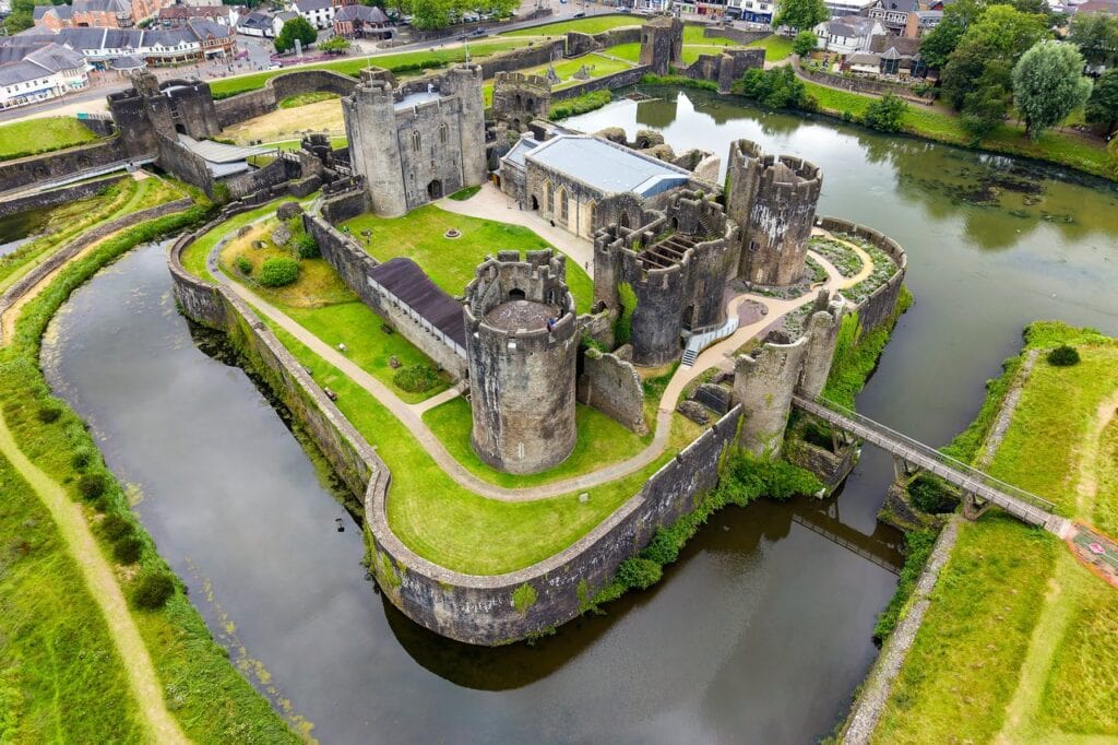 Caerphilly Castle 2 Aerial view of Caerphilly Castle's inner ward and its surrounding grassed platform, with moats and lakes curving around it and a footbridge crossing the water at the right