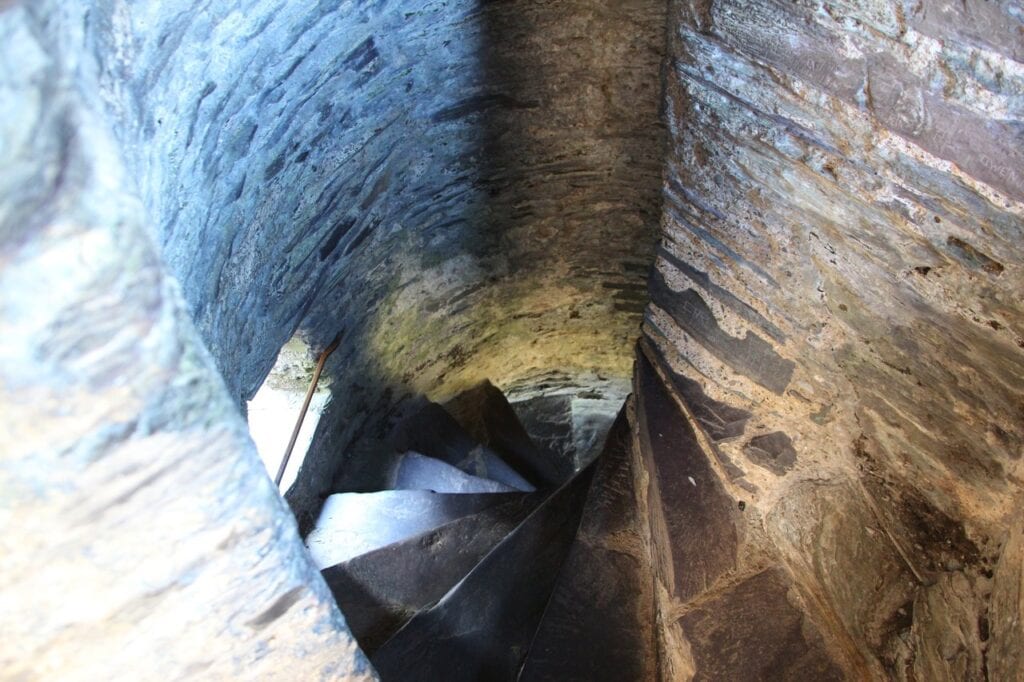 Dolbadarn Castle 9 Looking down a tight spiral staircase of slate steps between curved stone walls